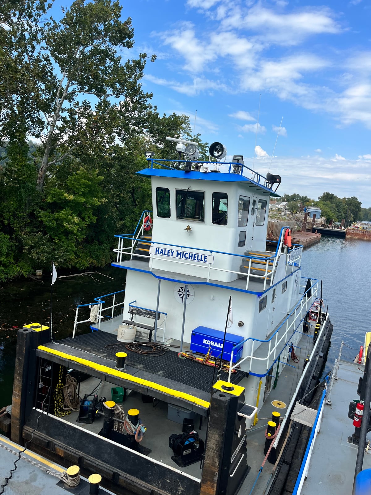 Haley Michelle moored beside the riverbank, viewed from above with its name across the front of the pilothouse.