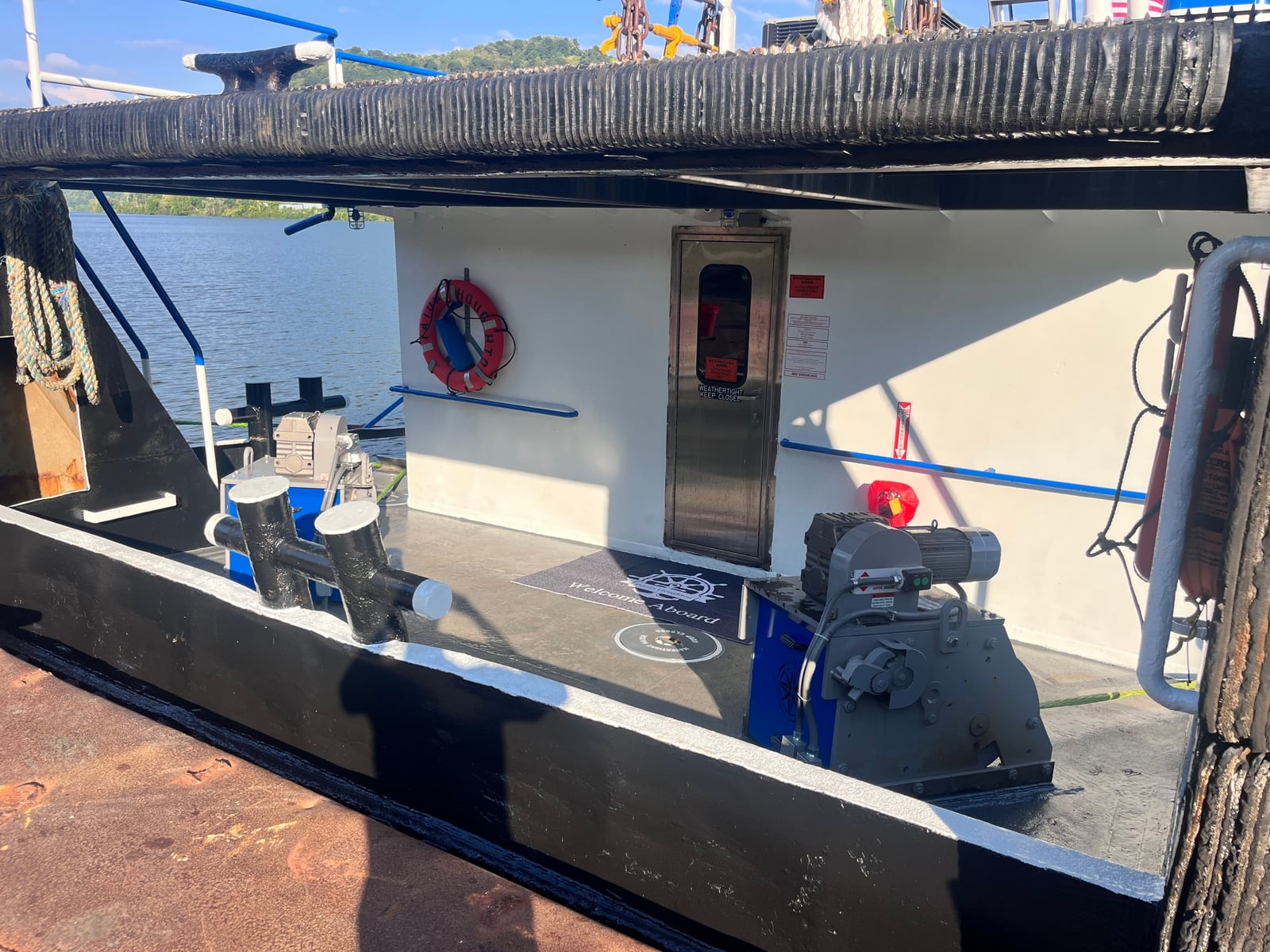 The working deck of Tatum Houghton, with winches, bollards and a life ring beside the cabin entrance.
